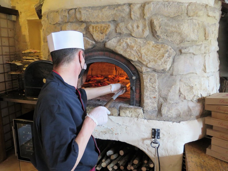 Le pizzaïolo du Bonséjour enfourne les pizzas dans le four à bois